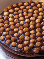 gluten-free chocolate and hazelnut cake made with organic ingredients: torta alla gianduja, made with organic dark chocolate & ground hazelnuts and hazelnut liqueur. Covered with dark chocolate ganache and roasted hazelnuts