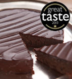 Great Taste award-winning gluten-free chocolate and almond cake. Made with organic dark chocolate & ground almonds, and Appleton Jamaica Rum, with a dash of almond extract. Contains almonds, all ingredients gluten free. Covered in dark chocolate ganache. Can be decorated. Delivery in London, can be posted