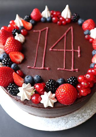 Glutenfree, dairyfree birthday cake: a layered chocolate and olive oil cake for a gluten-free birthday. Made with organic ingredients, filled and frosted with chocolate fudge buttercream. Decorated with berries, meringue kissed and piped message for collection in London 