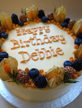 Award-winning Tunisian Orange & Almond Cake, made with gluten free and dairy free ingredients: organic ground almonds, oranges and extra-virgin olive oil. Here's a two-layer cake, filled and frosted with dairyfree orange buttercream and decorated with physalis, blueberries, rosemary sprigs and copper-dusted berries. Also available as a single-layer cake, with a sachet of organic icing sugar to dust before serving. All ingredients gluten-free and dairy-free. Delivery by hand available in London and the southeast