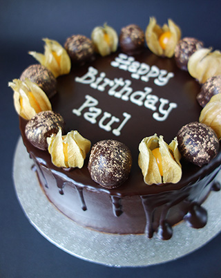 Award winning gluten-free rich chocolate cake made with organic ground almonds and dark chocolate. This one is made with organic coffee instead of rum. Two layers of cake, filled and frosted with dark chocolate ganache and decorated with fresh physalis and gold-dusted chocolate-dipped orange & almond cake truffles. Other toppings and dairyfree available. All ingredients gluten free