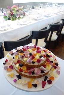 A layered Lemon and Pistachio Cake, made with gluten free, wheat free ingredients. Sprinkled with organic rose petals for a small summer wedding. All ingredients organic, gluten-free, wheat-free