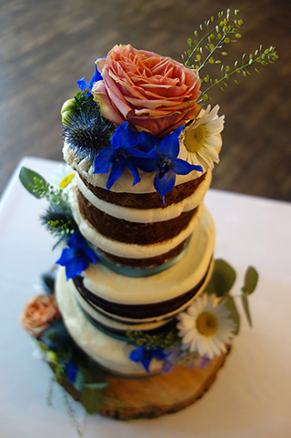 3-tier gluten-free vegan wedding cake for a wedding at The Barn in Tunbridge Wells. Vegan Carrot & Coconut Cake, vegan Chocolate Cake, and vegan Lemon Drizzle Cake. All filled and frosted with vegan buttercream and decorated with fresh flowers