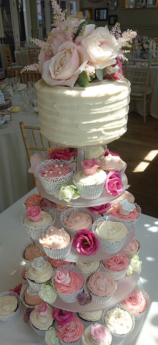 Cupcake wedding at The Secret Garden, Kent. Three flavours: zesty lemon, vegan chocolate, orange & almond. Topped by a vegan Banana & Peanut Butter Blondie cake for cutting. All ingredients gluten free. Decorated with fresh flowers from katiemackintosh.co.uk and sugar pearls & roses
