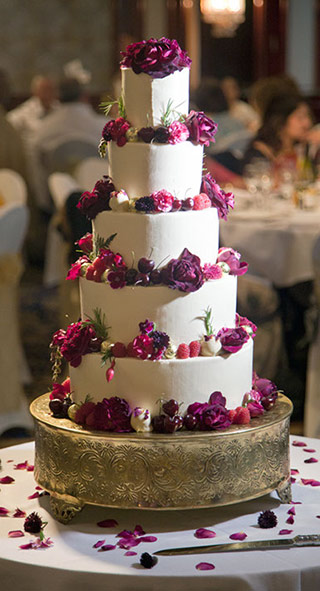 Glutenfree wedding: a fabulous gluten-free, wheat-free wedding cake. 3 tiers of award-winning, dairyfree Tunisian Orange & Almond Cake, and 2 tiers of dairy-free Chocolate & Olive Oil Cake. Filled and frosted with white chocolate Swiss meringue buttercream, and decorated with organic edible flowers and chocolate truffles. All ingredients gluten free. Price includes delivery and assembly at your London venue. Organic edible flowers and foliage