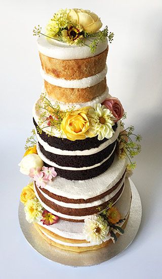 4-tier gluten-free, vegan wedding cake, made with organic ingredients. From the top: Lemon Cake, Dark Chocolate Cake, Carrot Cake, Orange & Almond Cake. All made with gluten free organic ingredients, no animal products. Decorated with organic edible flowers from maddocksfarmorganics.co.uk. Wedding service includes tasting consultation and delivery and assembly at your London venue