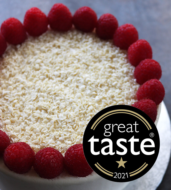 Lots of amazing flavours to choose from! In the pic, a white chocolate & raspberry cake, Great Taste award winner in 2021. All ingredients gluten free. Filled and frosted with organic white chocolate buttercream, topped with berries and white chocolate shavings. Delivery in London