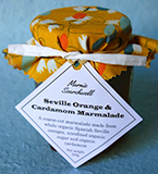 Cardamom Marmalade: Made with hand-cut organic Spanish Seville oranges, spiced with crushed cardamom seeds and pods. Finished with a fabulous fabric topper tied with paper ribbon 